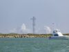 SpaceX cancela el lanzamiento número 13 de Starship Torre de lanzamiento de Starship rodeada de humo blanco con un yate navegando en primer plano en Texas.