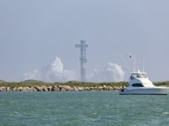 SpaceX cancela el lanzamiento número 13 de Starship Torre de lanzamiento de Starship rodeada de humo blanco con un yate navegando en primer plano en Texas.