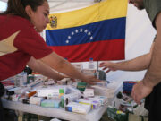 Terremotos en Venezuela activan ayuda urgente del PMA Personal de salud organiza cajas de medicamentos en una mesa con la bandera de Venezuela al fondo.
