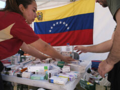 Terremotos en Venezuela activan ayuda urgente del PMA Personal de salud organiza cajas de medicamentos en una mesa con la bandera de Venezuela al fondo.