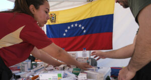 Terremotos en Venezuela activan ayuda urgente del PMA Personal de salud organiza cajas de medicamentos en una mesa con la bandera de Venezuela al fondo.
