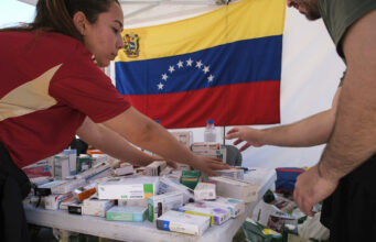 Terremotos en Venezuela activan ayuda urgente del PMA Personal de salud organiza cajas de medicamentos en una mesa con la bandera de Venezuela al fondo.