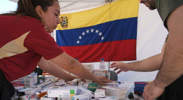 Terremotos en Venezuela activan ayuda urgente del PMA Personal de salud organiza cajas de medicamentos en una mesa con la bandera de Venezuela al fondo.