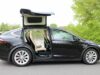 Precios de autos usados eléctricos suben en el mercado Tesla Model X negro con puertas Falcon desplegadas, auto usado eléctrico que encabeza la subida de precios.