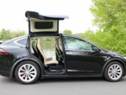 Precios de autos usados eléctricos suben en el mercado Tesla Model X negro con puertas Falcon desplegadas, auto usado eléctrico que encabeza la subida de precios.