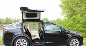 Precios de autos usados eléctricos suben en el mercado Tesla Model X negro con puertas Falcon desplegadas, auto usado eléctrico que encabeza la subida de precios.