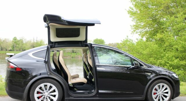 Precios de autos usados eléctricos suben en el mercado Tesla Model X negro con puertas Falcon desplegadas, auto usado eléctrico que encabeza la subida de precios.