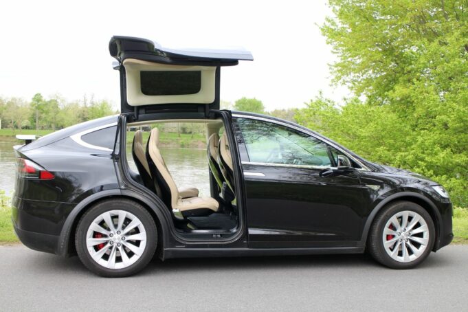 Precios de autos usados eléctricos suben en el mercado Tesla Model X negro con puertas Falcon desplegadas, auto usado eléctrico que encabeza la subida de precios.