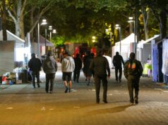 Tiroteo en Seattle deja tres muertos y cuatro heridos Personas caminando por la zona del tiroteo en Seattle Center rodeada de carpas nocturnas.