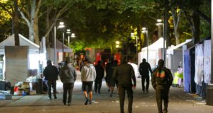 Tiroteo en Seattle deja tres muertos y cuatro heridos Personas caminando por la zona del tiroteo en Seattle Center rodeada de carpas nocturnas.