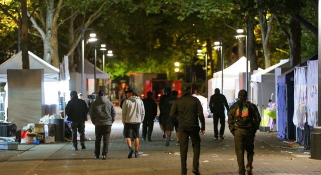 Tiroteo en Seattle deja tres muertos y cuatro heridos Personas caminando por la zona del tiroteo en Seattle Center rodeada de carpas nocturnas.