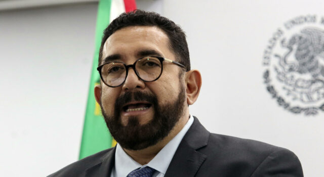 Ulises Lara renuncia a la fiscalía de casos relevantes de México Ulises Lara López con traje oscuro y lentes durante una conferencia de prensa en la fiscalía de México.