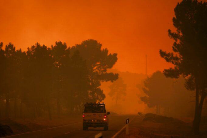 Incendio en Portugal moviliza a más de 800 bomberos Vehículo de emergencia transitando por carretera rodeada de humo por incendio forestal en Portugal.