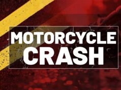 Accidente fatal en Alabama deja un motociclista muerto Gráfico de noticias con la leyenda Motorcycle Crash sobre fondo rojo y líneas amarillas de carretera en Alabama.