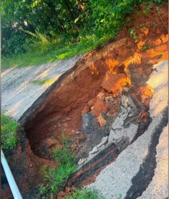 Vecinos reparan camino privado en el condado de Blount Socavón en carretera de tierra y asfalto en el condado de Blount, Alabama, antes de ser reparado por vecinos.