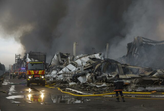 Bomberos atienden incendio masivo en almacén destruido tras un ataque ruso en la región de Kiev.
