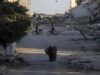 Ataques en Gaza dejan diez muertos y rompen la tregua Civiles y ciclistas recorren una calle rodeada de escombros y edificios destruidos tras ataques en Gaza.