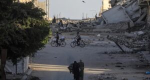 Ataques en Gaza dejan diez muertos y rompen la tregua Civiles y ciclistas recorren una calle rodeada de escombros y edificios destruidos tras ataques en Gaza.