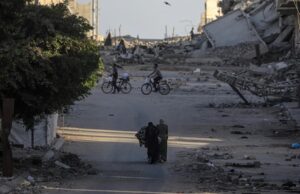 Ataques en Gaza dejan diez muertos y rompen la tregua Civiles y ciclistas recorren una calle rodeada de escombros y edificios destruidos tras ataques en Gaza.