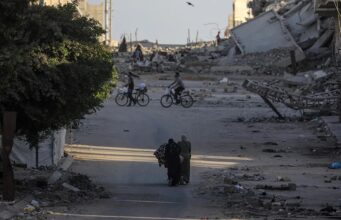 Ataques en Gaza dejan diez muertos y rompen la tregua Civiles y ciclistas recorren una calle rodeada de escombros y edificios destruidos tras ataques en Gaza.