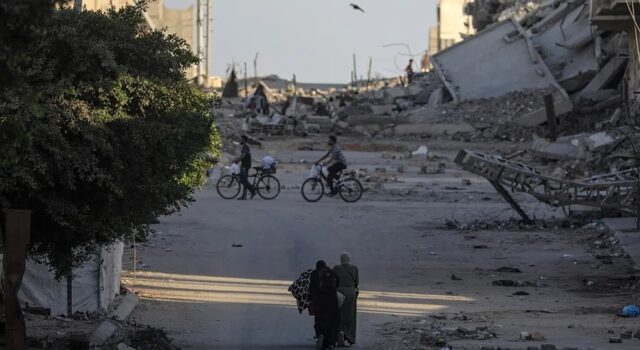 Ataques en Gaza dejan diez muertos y rompen la tregua Civiles y ciclistas recorren una calle rodeada de escombros y edificios destruidos tras ataques en Gaza.
