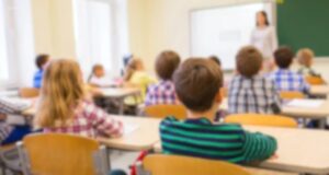 Escuelas de Alabama destacan en el nuevo ranking educativo Estudiantes sentados en sus pupitres dentro de un aula de clases con una profesora al frente en Alabama.