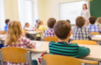 Escuelas de Alabama destacan en el nuevo ranking educativo Estudiantes sentados en sus pupitres dentro de un aula de clases con una profesora al frente en Alabama.