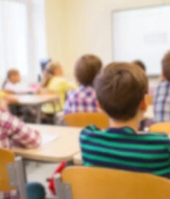 Escuelas de Alabama destacan en el nuevo ranking educativo Estudiantes sentados en sus pupitres dentro de un aula de clases con una profesora al frente en Alabama.