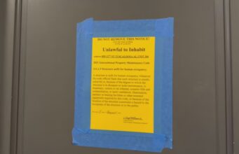 Moho en apartamentos deja sin vivienda a universitarios Cartel oficial amarillo pegado en una puerta que declara inhabitable un apartamento por moho en Tuscaloosa.