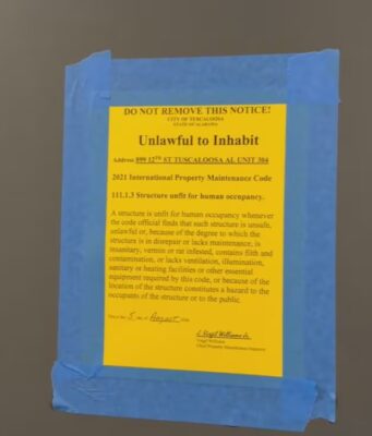 Moho en apartamentos deja sin vivienda a universitarios Cartel oficial amarillo pegado en una puerta que declara inhabitable un apartamento por moho en Tuscaloosa.
