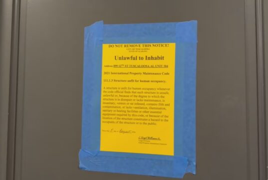 Moho en apartamentos deja sin vivienda a universitarios Cartel oficial amarillo pegado en una puerta que declara inhabitable un apartamento por moho en Tuscaloosa.
