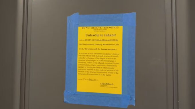 Moho en apartamentos deja sin vivienda a universitarios Cartel oficial amarillo pegado en una puerta que declara inhabitable un apartamento por moho en Tuscaloosa.