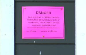 Homewood aprueba fondos para desalojados por clausura Letrero rosa de advertencia que declara un edificio inhabitable por bomberos de Homewood, Alabama.