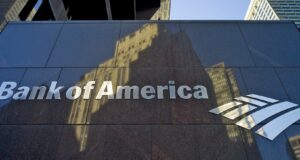 Inversión millonaria de Bank of America en infraestructura Fachada de Bank of America con letrero metálico que anuncia inversión millonaria en infraestructura.