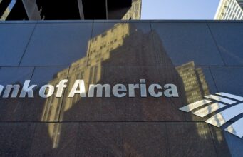 Inversión millonaria de Bank of America en infraestructura Fachada de Bank of America con letrero metálico que anuncia inversión millonaria en infraestructura.