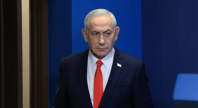 Netanyahu denuncia un complot iraní para matar a su hijo Benjamín Netanyahu con traje oscuro y corbata roja en un acto oficial tras denunciar complot de Irán.