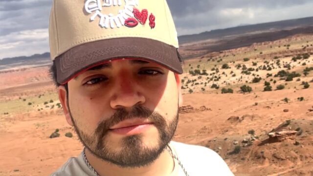 cesar-gastelum-influencer-asesinado-culiacan Selfie de César Gastélum, influencer asesinado en Culiacán, usando gorra en un paisaje desértico.