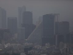 Contaminación atmosférica agrava la artritis reumatoide Vista panorámica de edificios urbanos cubiertos por una densa capa de contaminación atmosférica y smog.