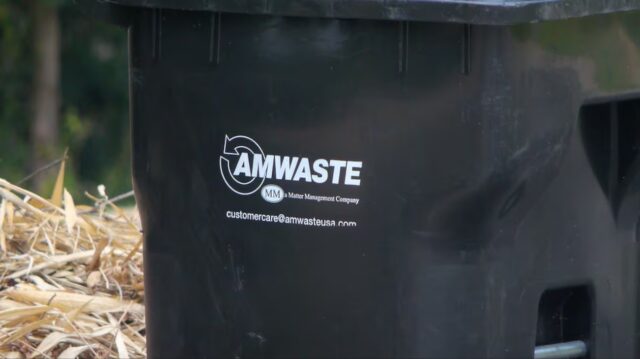 Contenedor de basura negro de la empresa Amwaste colocado para recolección en Vestavia Hills.