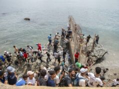 Marruecos culpa a fallo judicial español por crisis en Ceuta Decenas de personas agrupadas sobre rocas intentando rodear el espigón fronterizo con valla metálica hacia Ceuta.