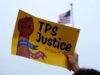 Deportados de EE. UU. llegan a Haití tras la cancelación del TPS Cartel de protesta por el fin del TPS para deportados de Haití frente a bandera de Estados Unidos.