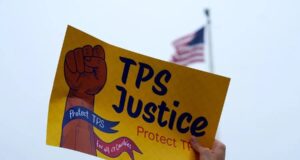 Deportados de EE. UU. llegan a Haití tras la cancelación del TPS Cartel de protesta por el fin del TPS para deportados de Haití frente a bandera de Estados Unidos.