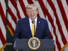 EE. UU. planea cobrar una nueva tarifa de 100.000 dólares para visas H-1B Donald Trump sonriendo en un podio presidencial ante banderas de EE. UU. respecto a las tarifas de visas H-1B.