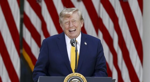 EE. UU. planea cobrar una nueva tarifa de 100.000 dólares para visas H-1B Donald Trump sonriendo en un podio presidencial ante banderas de EE. UU. respecto a las tarifas de visas H-1B.