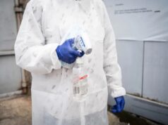 Brote de ébola en el Congo supera los cinco mil contagios Personal sanitario con traje de protección y guantes azules sosteniendo un termómetro y alcohol en gel para el control de la temperatura.