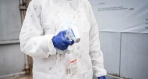 Brote de ébola en el Congo supera los cinco mil contagios Personal sanitario con traje de protección y guantes azules sosteniendo un termómetro y alcohol en gel para el control de la temperatura.
