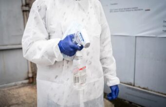 Brote de ébola en el Congo supera los cinco mil contagios Personal sanitario con traje de protección y guantes azules sosteniendo un termómetro y alcohol en gel para el control de la temperatura.