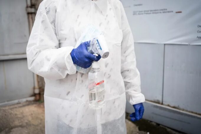 Brote de ébola en el Congo supera los cinco mil contagios Personal sanitario con traje de protección y guantes azules sosteniendo un termómetro y alcohol en gel para el control de la temperatura.