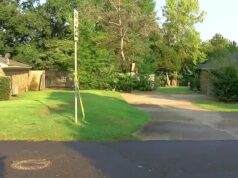 Detienen a tercer menor por homicidio en Tuscaloosa Cinta de precaución amarilla amarrada a una señal de tránsito frente a casas residenciales en Alabama.