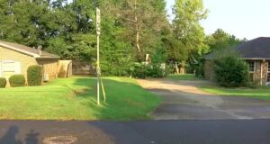 Detienen a tercer menor por homicidio en Tuscaloosa Cinta de precaución amarilla amarrada a una señal de tránsito frente a casas residenciales en Alabama.